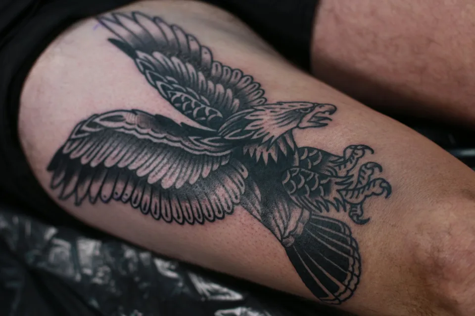 A traditional eagle in black and grey on a thigh