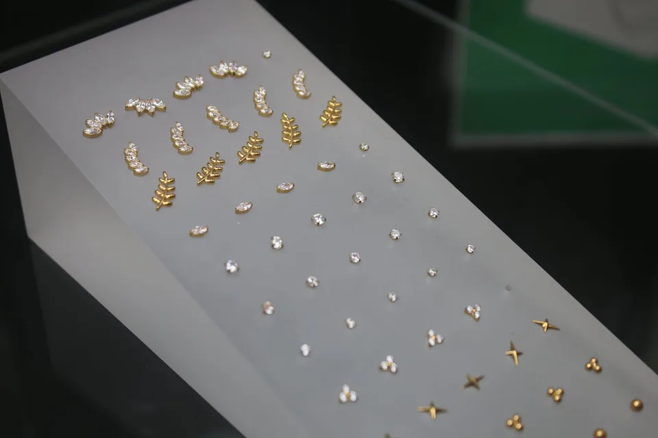 Gold piercing jewellery laid out on the display tray