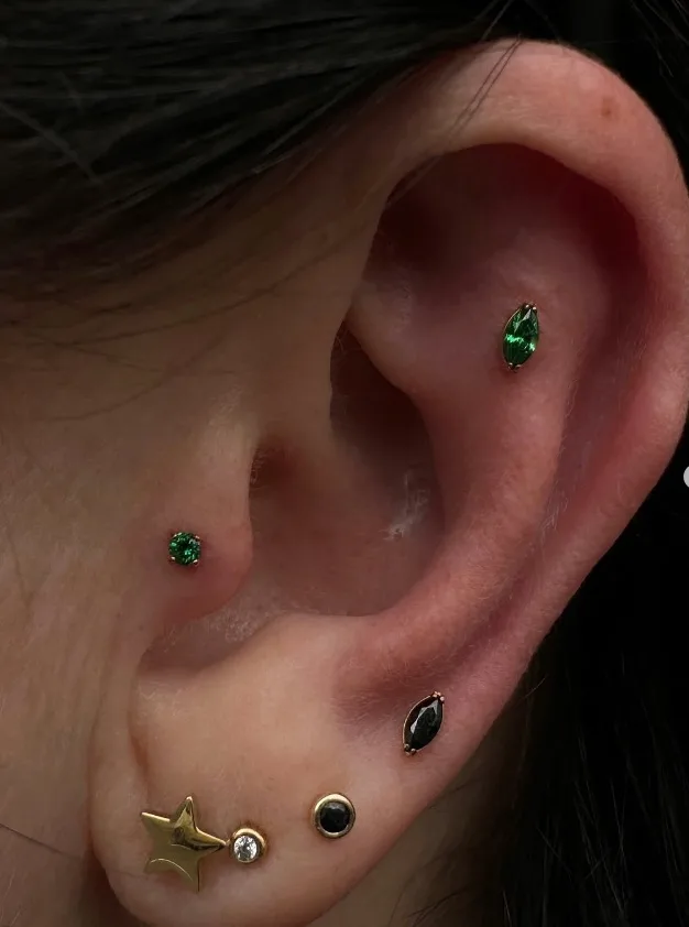 An ear with green gemstone jewellery
